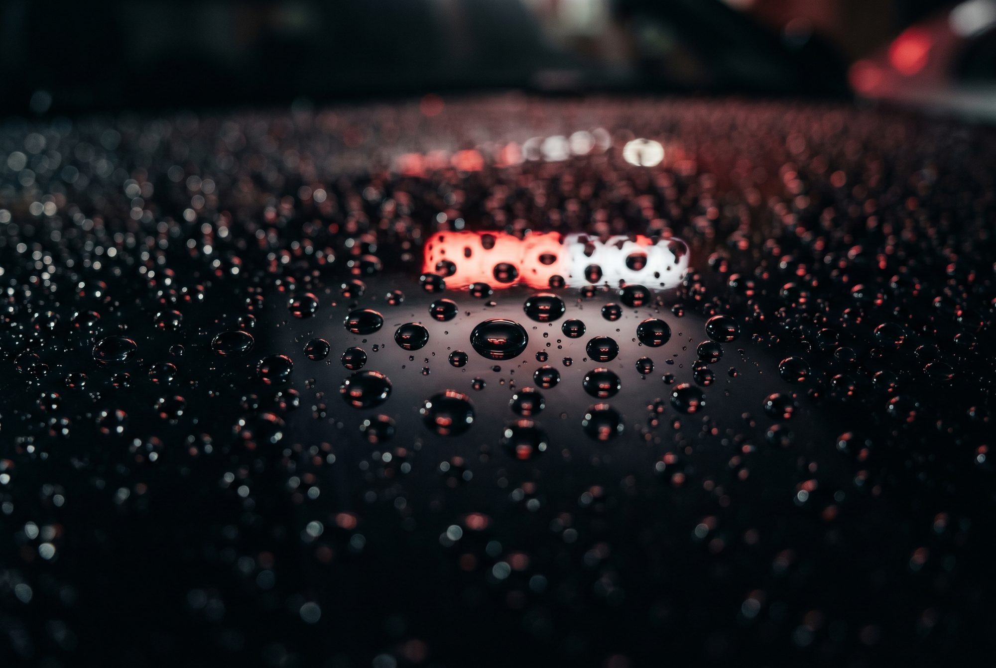 Water beading on a ceramic-coated black car